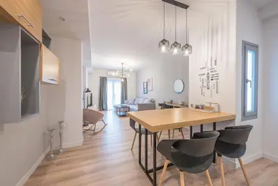 a dining room and living room with a table and chairs at Elegant & Spacious Apartment in Athens