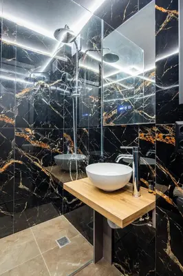 a bathroom with a sink and a black tiled wall at The Acropolis Pathway in Athens