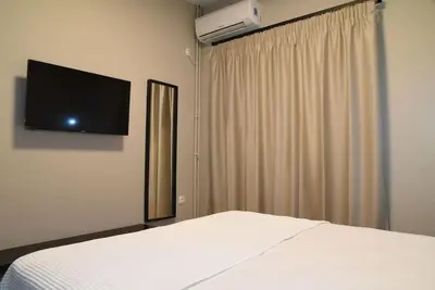 a bedroom with a bed and a television on the wall at Elegant Central 2BR & 2 Ensuite Baths, Near Metro in Athens