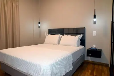 a bedroom with a large bed with white sheets and pillows at Elegant Central 2BR & 2 Ensuite Baths, Near Metro in Athens