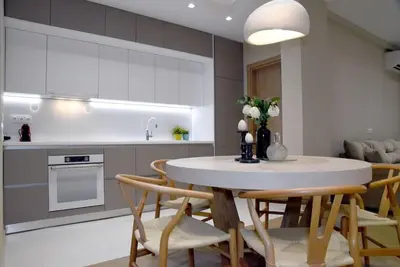 a kitchen and dining room with a table and chairs at Elegant Central 2BR & 2 Ensuite Baths, Near Metro in Athens