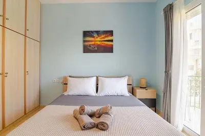 a bedroom with a bed with two slippers on it at Seaside Escape Apartments - Poseidon in Palaiá Fókaia