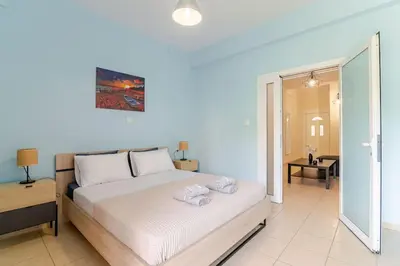 a bedroom with a large white bed in a room at Seaside Escape Apartments - Poseidon in Palaiá Fókaia