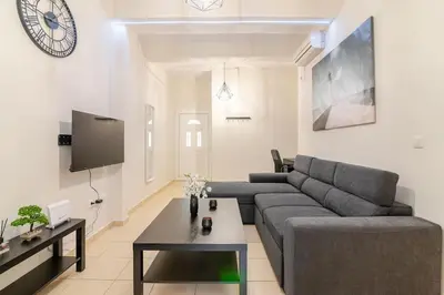 a living room with a couch and a table at Seaside Escape Apartments - Poseidon in Palaiá Fókaia