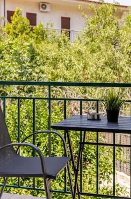 a table and a chair on a balcony at Seaside Escape Apartments - Poseidon in Palaiá Fókaia