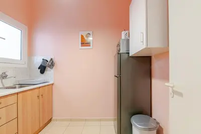a kitchen with a refrigerator and a sink at Seaside Escape Apartments - Poseidon in Palaiá Fókaia