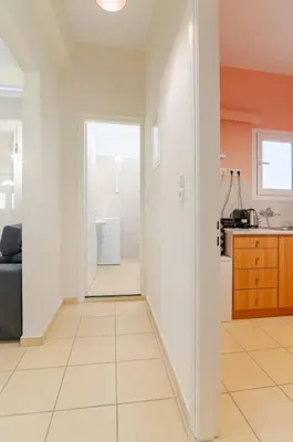 a white hallway with a door leading to a bathroom at Seaside Escape Apartments - Poseidon in Palaiá Fókaia