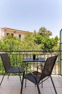 a table and two chairs on a balcony at Seaside Escape Apartments - Poseidon in Palaiá Fókaia