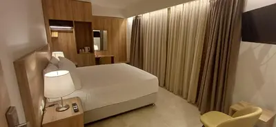 a bedroom with a large white bed in a room at ALPHA APARTMENTS Free Shuttle from and to the Airport in Spáta