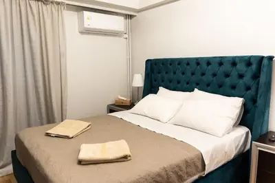 a bedroom with a large bed with two towels on it at Sympatico Glyfada Downtown in Athens