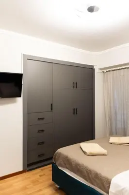 a bedroom with a bed and a large closet at Sympatico Glyfada Downtown in Athens