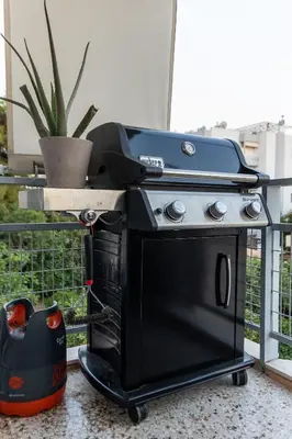 a black stove on a cart with a grill at Sympatico Glyfada Downtown in Athens