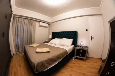 a bedroom with a large bed with a green headboard at Sympatico Glyfada Downtown in Athens