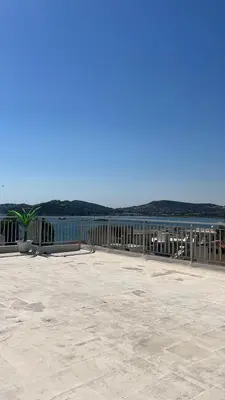 a wooden fence next to a body of water at Athens Palaia Fokaia Entire Flat 2 bedrooms with panoramic sea views and a massive veranda , only steps away from the beach and amenities in Palaiá Fókaia