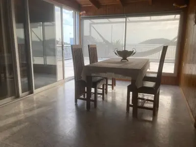 a dining room with a table and chairs and a large window at Athens Palaia Fokaia Entire Flat 2 bedrooms with panoramic sea views and a massive veranda , only steps away from the beach and amenities in Palaiá Fókaia
