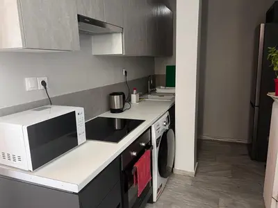 a small kitchen with a microwave and a stove at Athens Palaia Fokaia Entire Flat 2 bedrooms with panoramic sea views and a massive veranda , only steps away from the beach and amenities in Palaiá Fókaia