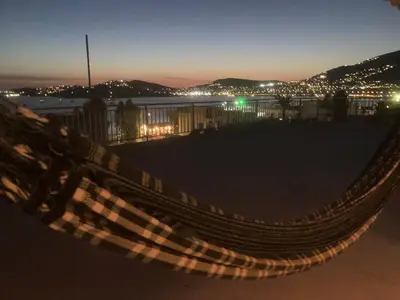 a hammock on the beach at night at Athens Palaia Fokaia Entire Flat 2 bedrooms with panoramic sea views and a massive veranda , only steps away from the beach and amenities in Palaiá Fókaia
