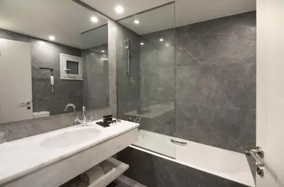 a bathroom with a sink and a shower and a tub at Astor Hotel Athens in Athens