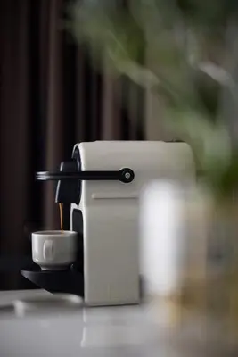 a coffee maker sitting on a table with a cup at Astor Hotel Athens in Athens