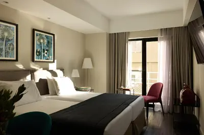 a hotel room with a bed and a window at Astor Hotel Athens in Athens