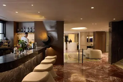 a man standing at a bar in a hotel at Astor Hotel Athens in Athens
