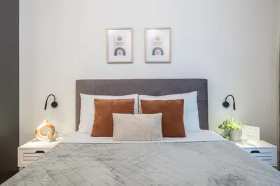 a bedroom with a bed with two lamps and two pillows at Athens Home in Athens