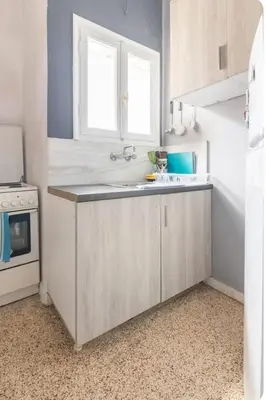 a kitchen with white cabinets and a sink and a window at Cozy Penthouse in Athens Center in Athens