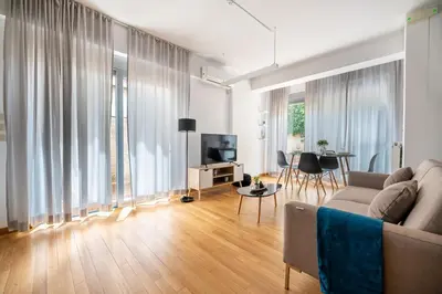 a living room with a couch and a television and a table at Chic 1BR Apartment in Neo Psichiko in Athens