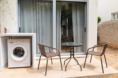 a patio with a table and chairs and a washing machine at Chic 1BR Apartment in Neo Psichiko in Athens