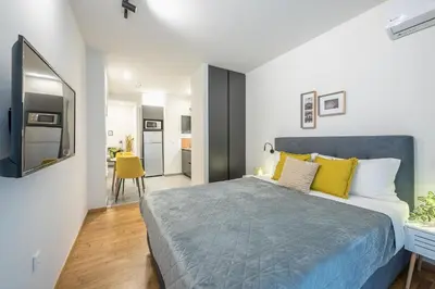 a bedroom with a large bed with yellow pillows at Home In Athens in Athens