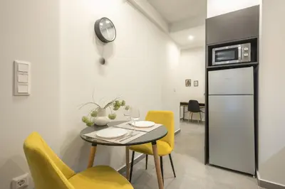 a dining room with a table and yellow chairs at Home In Athens in Athens
