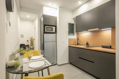 a kitchen with a glass table and a counter top at Home In Athens in Athens