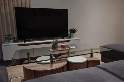 a living room with a tv and a glass table at Elegant 42sqm Apartment in Lycabettus in Athens