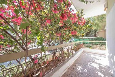 a fence with pink flowers in a garden at Home In The Alimos Marina in Athens