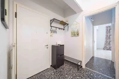 a hallway with a white door and a black refrigerator at Home In The Alimos Marina in Athens