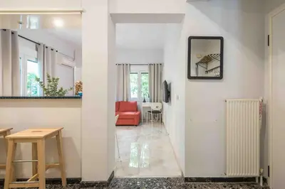 a living room with a red couch and a white wall at Home In The Alimos Marina in Athens