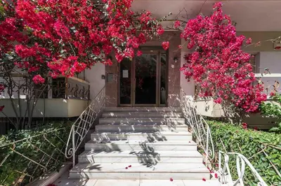 a set of stairs with pink flowers in front of a building at Home In The Alimos Marina in Athens