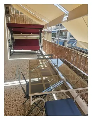 a glass table and a chair on a balcony at Υπέροχο διαμερίσμα στο κέντρο της Αθήνας in Athens