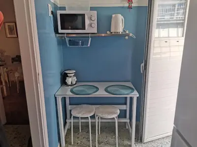 a small table with two stools and a microwave at Υπέροχο διαμερίσμα στο κέντρο της Αθήνας in Athens