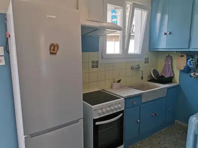 a small kitchen with blue cabinets and a sink at Υπέροχο διαμερίσμα στο κέντρο της Αθήνας in Athens
