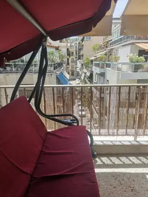a bed on a balcony with a view of a city at Υπέροχο διαμερίσμα στο κέντρο της Αθήνας in Athens