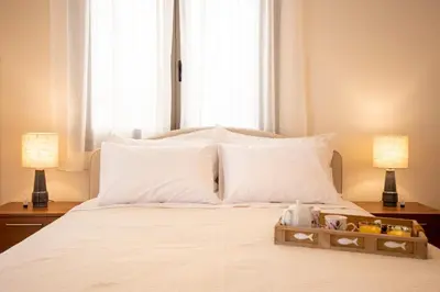 a bed with white pillows and a tray on it at Sea La Vie in Agia Marina Aegina