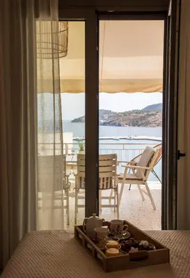 a hotel room with a bed with a tray of food at Sea La Vie in Agia Marina Aegina