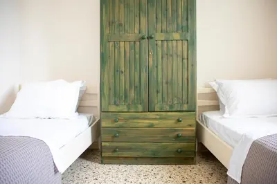 a bedroom with two beds and a green cabinet at Sea La Vie in Agia Marina Aegina