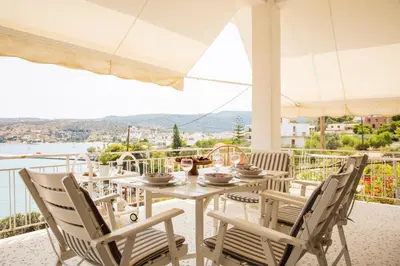a table and chairs on a balcony with a view at Sea La Vie in Agia Marina Aegina