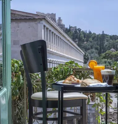 a table with a plate of food on a balcony at Ancient Agora Plaka in Athens