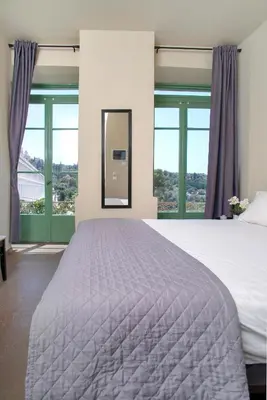 a bedroom with a large bed and large windows at Ancient Agora Plaka in Athens