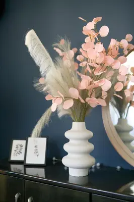 a vase with feathers on a table with a mirror at Sea-View Apt Argyroupoli, Athens in Athens