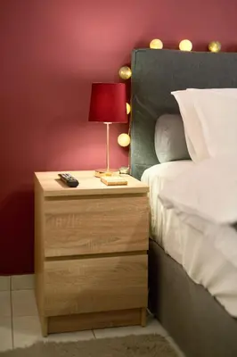 a nightstand with a lamp on it next to a bed at Sea-View Apt Argyroupoli, Athens in Athens