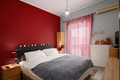 a red bedroom with a bed and a red wall at Sea-View Apt Argyroupoli, Athens in Athens
